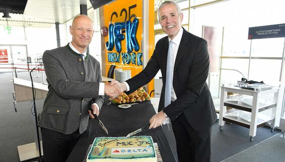 The picture shows Jost Lammers (CEO Munich Airport) on the left and Matteo Curcio (Delta Airlines Senior Vice President Europe, Middle-East, Africa, India) cutting a cake at the gate on the occasion of the first flight to New York, which was then distributed among the passengers.