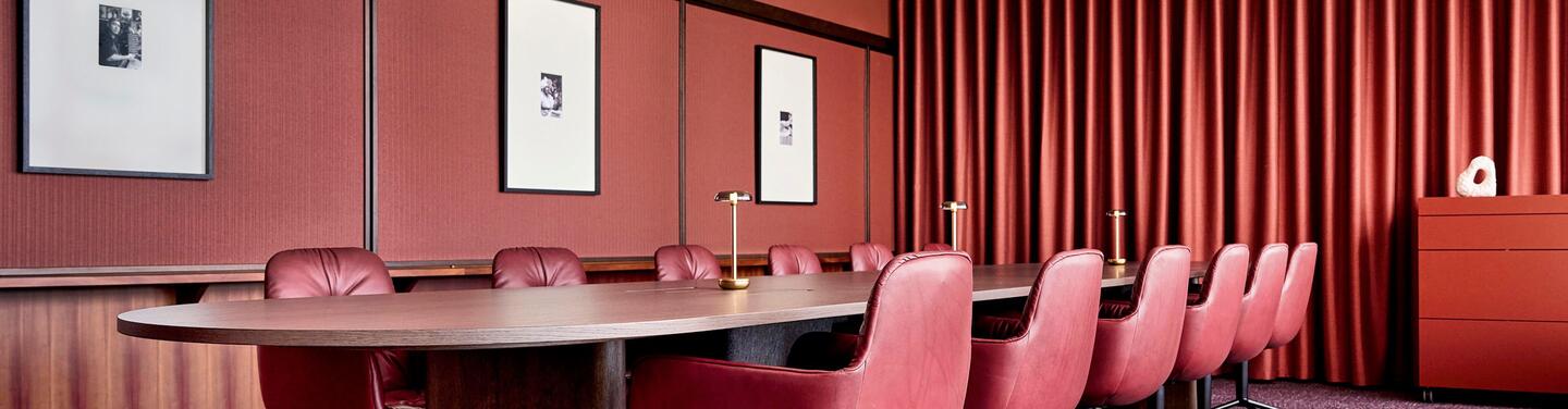 municon Havanna Lounge Eleganter Meeting- und Loungebereich in warmen Rottönen mit hochwertiger Ausstattung und ruhiger, konzentrierter Atmosphäre – ideal für Besprechungen und vertrauliche Gespräche.
