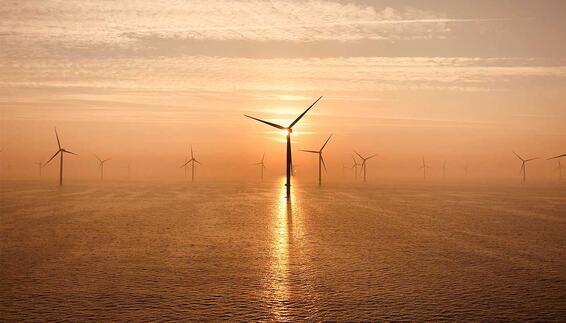 Der Flughafen München und der Energieerzeuger RWE haben im Februar 2026 einen Stromliefervertrag unterzeichnet Offshore‑Windräder im Meer bei Sonnenuntergang