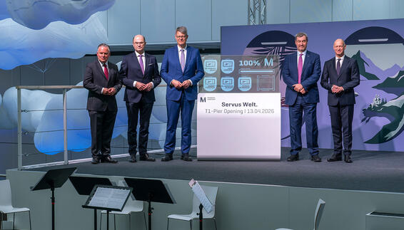 Feierliche Eröffnung des Terminal 1-Piers am Flughafen München fünf männer stehen neben einem oled display welches 100% anzeigt und den pier eröffnet hat